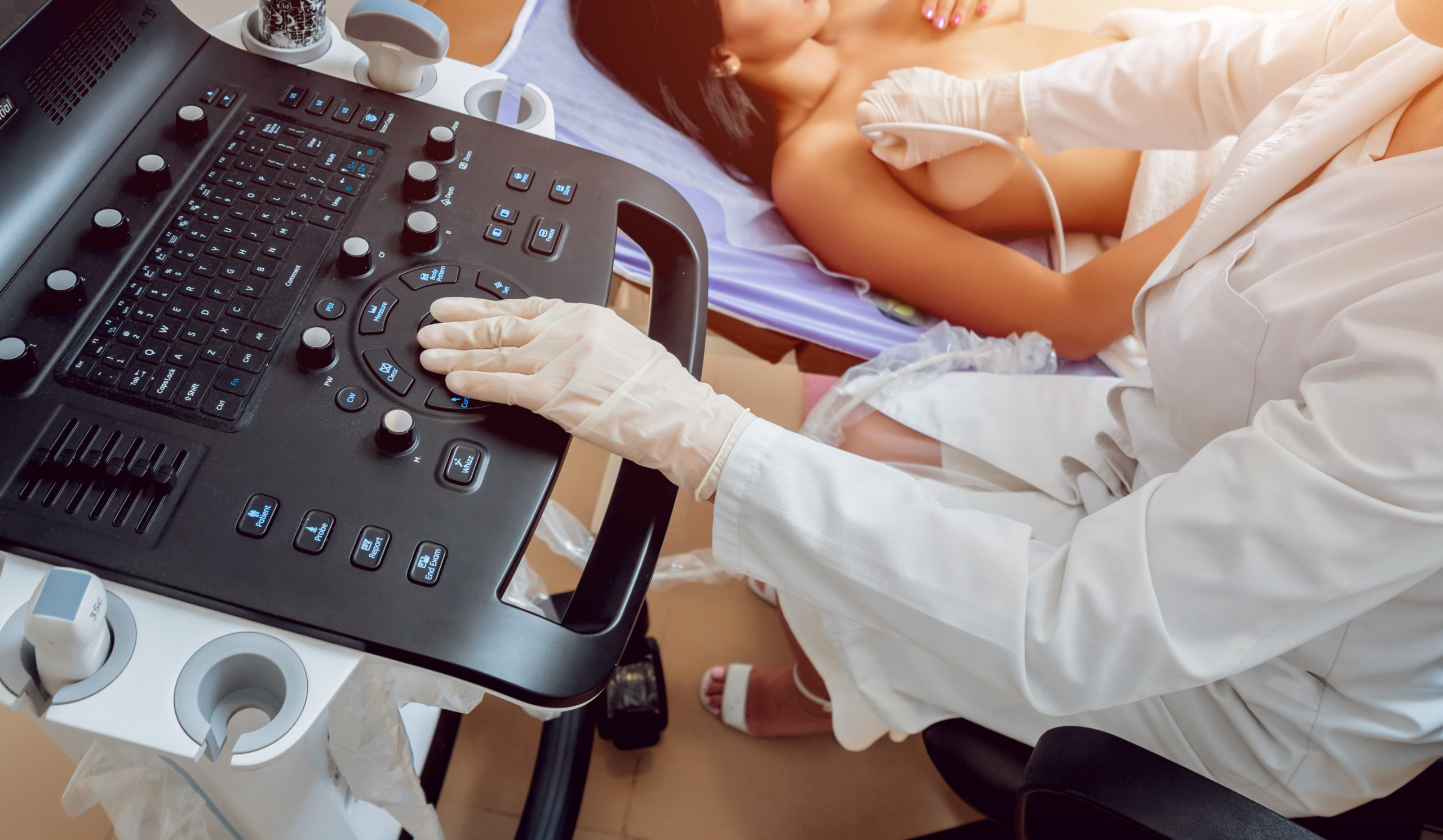 Gynecologist performing breast examination for her patient using ultrasound scanner. Sonography. Medical equipment healthcare. Ultrasound scanning.